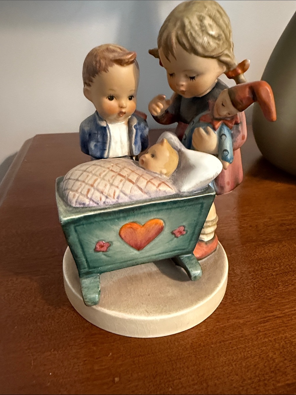 MJ HUMMEL. Blessed  EVent Ceramic Cradle Figurine in Green, Pink and Blue